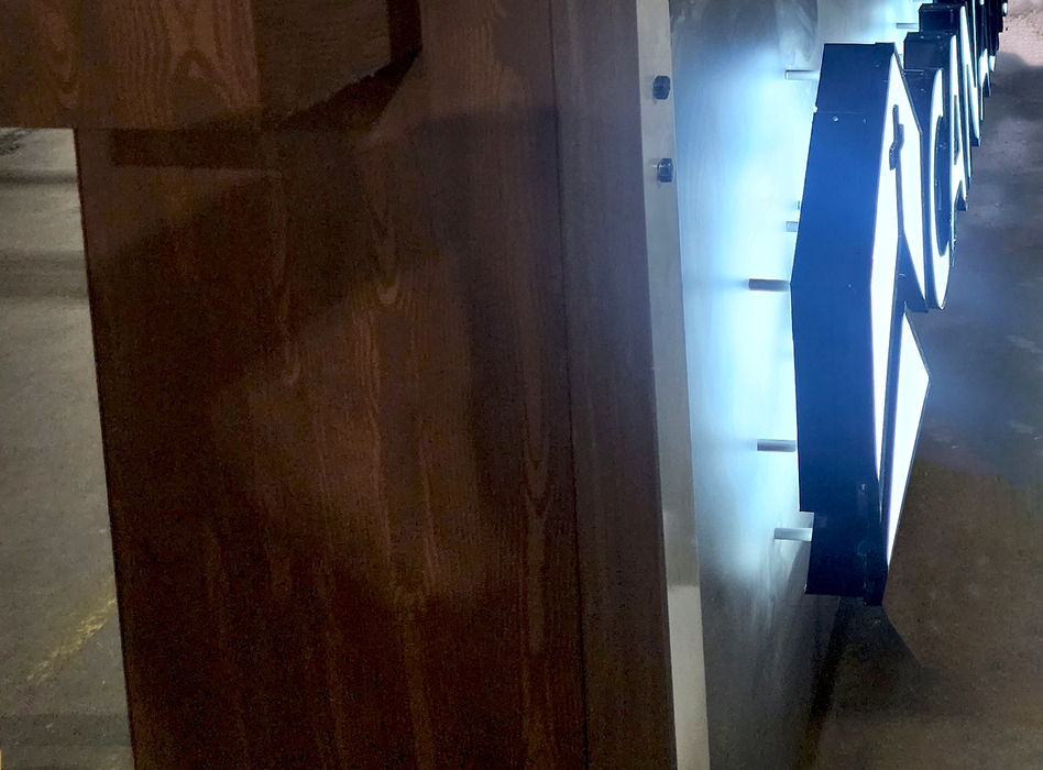 Closeup view of the top of a freestanding monument sign with LED halo-lit channel letters in the Mello Signs facility in DFW.