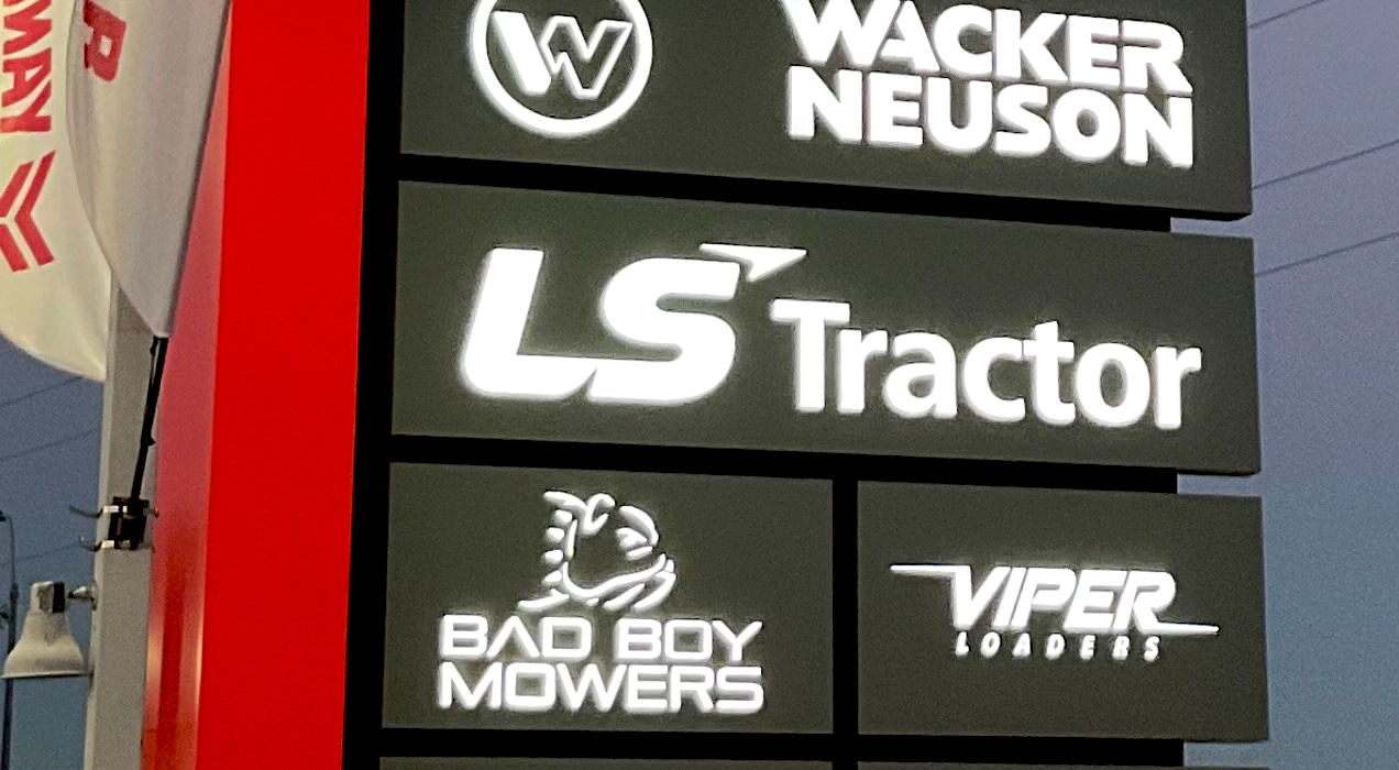 Closeup of a red & gray freestanding monument sign with company brand names in white, installed by Mello Signs Fort Worth.