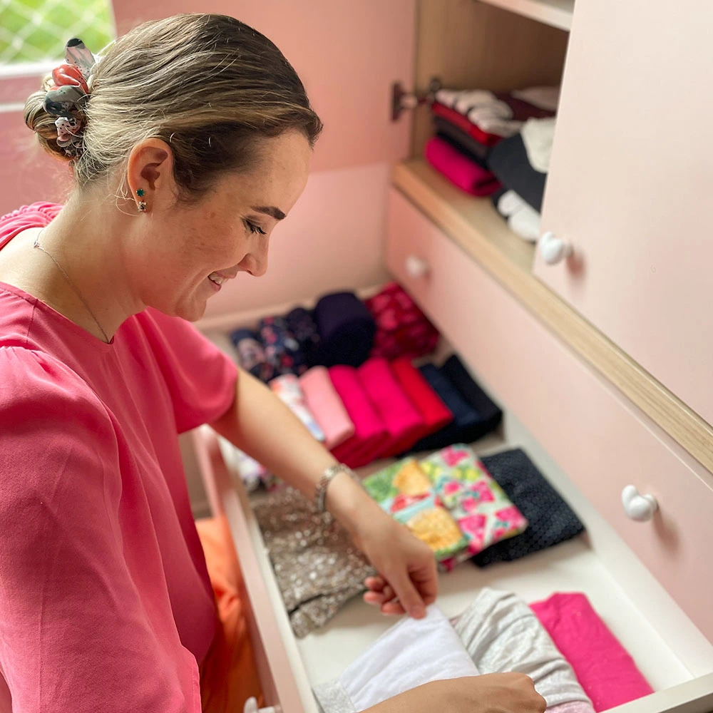 mulher organizendo um guarda-roupas rosa