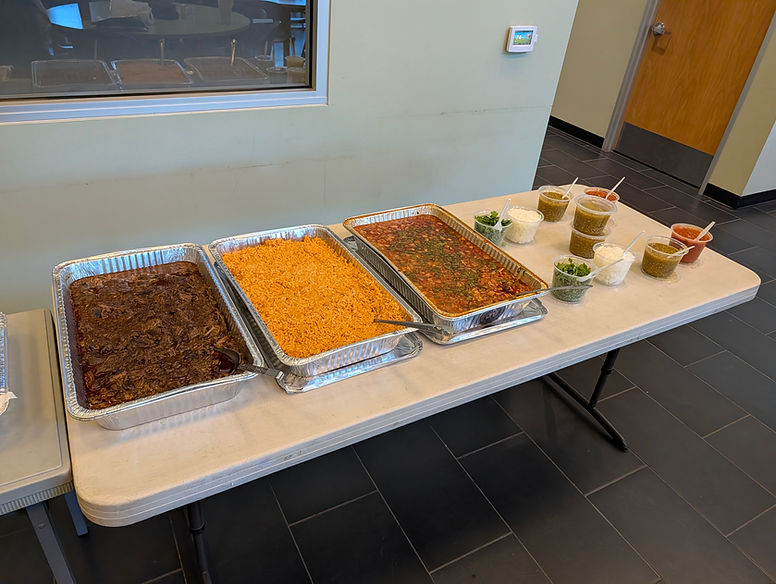 JV's Original Grill catering buffet with shredded beef, Mexican rice, beans, and assorted toppings.