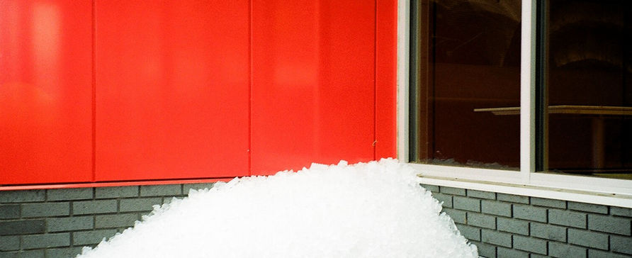 35mm film photo of a huge amount of wasted ice cubes outside a McDonalds 