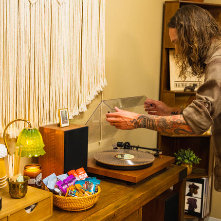 A stylist arranging vinyl records next to complimentary snacks and beverages
