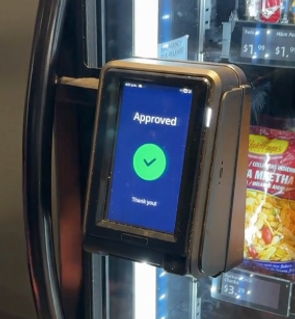 Customer using touch screen payment on vending machine