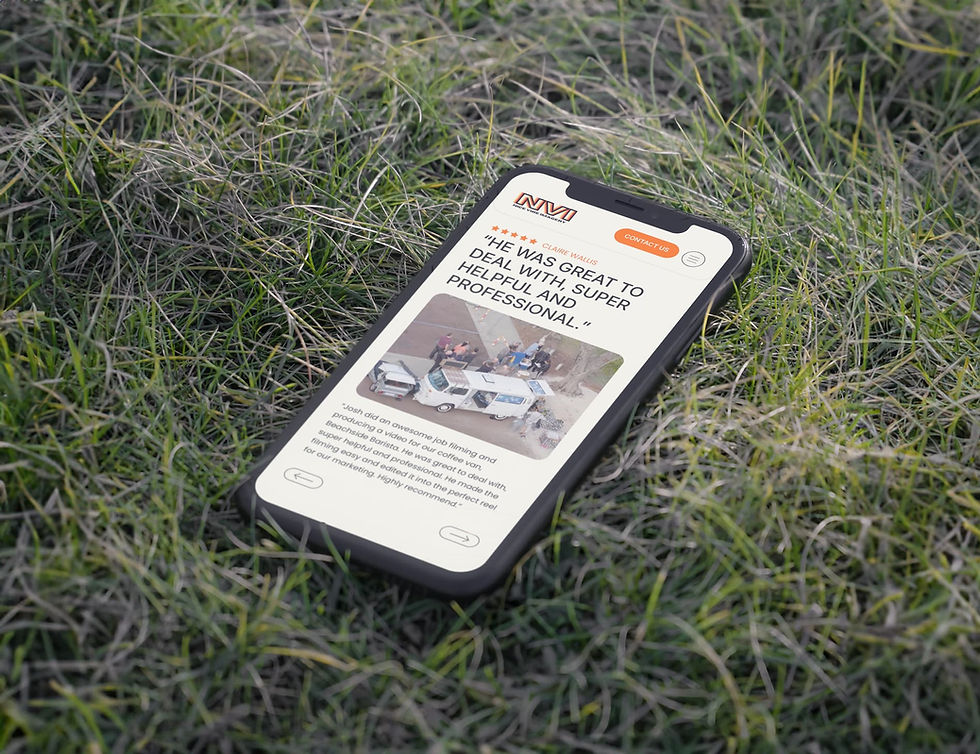 Mobile phone displaying the Nice Vibe Imagery website design, shown outdoors on grass to highlight responsive mobile design.