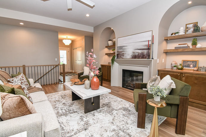 A closer view of the staged living room highlighting the fireplace, built-ins and furniture layout.