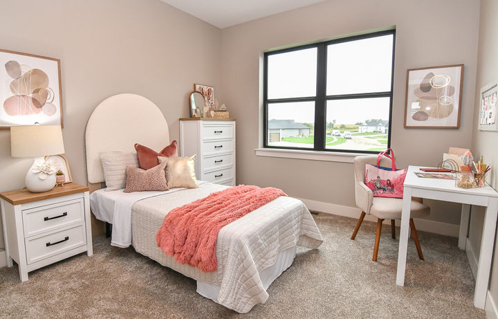 Staged children's bedroom in a Cedar Falls Parade Home with warm neutral furnishings and decor.