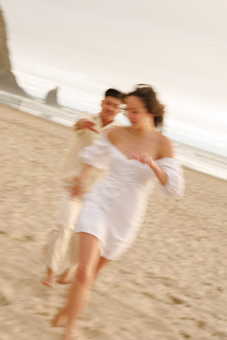 Couple chasing each other running at Cannon Beach for engagement photography