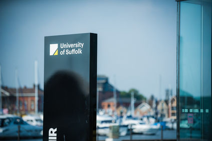A campus sign bearing the words "University of Suffolk"
