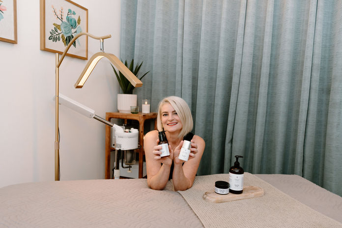 A Certified Vixen team member presenting skincare products in the salon treatment room in Solana Beach.