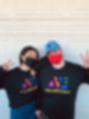 Music Therapy Internship Supervisor, Christina Ebersole (left), standing with Music therapy Intern Marie Metcalfe (right). Both are wearing able arts work shirts and holding up peace signs.