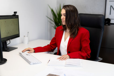 Civil engineer working on computer with printed plans on desk
