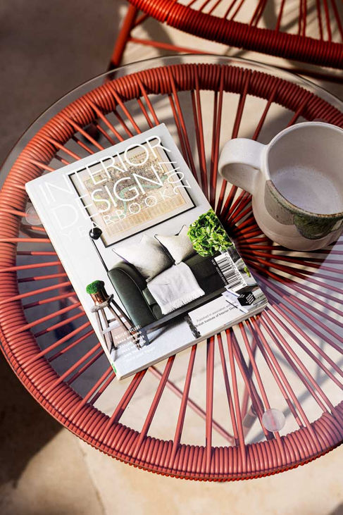 Outdoor red chair with open book and reading glasses in Algarve home