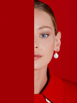 Close-up portrait of a woman in bold red fashion with statement earrings – luxury editorial photography.