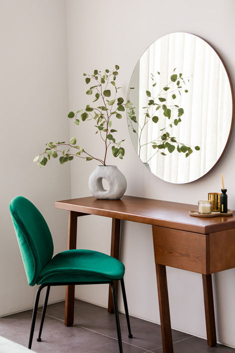 Luxury interior design photography featuring a modern wooden desk, round mirror, and green velvet chair, ideal for home decor branding