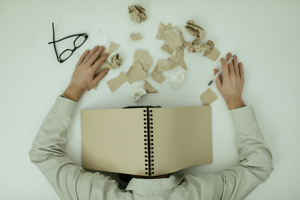 head on desk with notebook covering it showing burnout