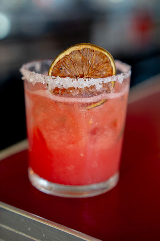 Refreshing cocktail with an orange slice garnish and a sugared rim.