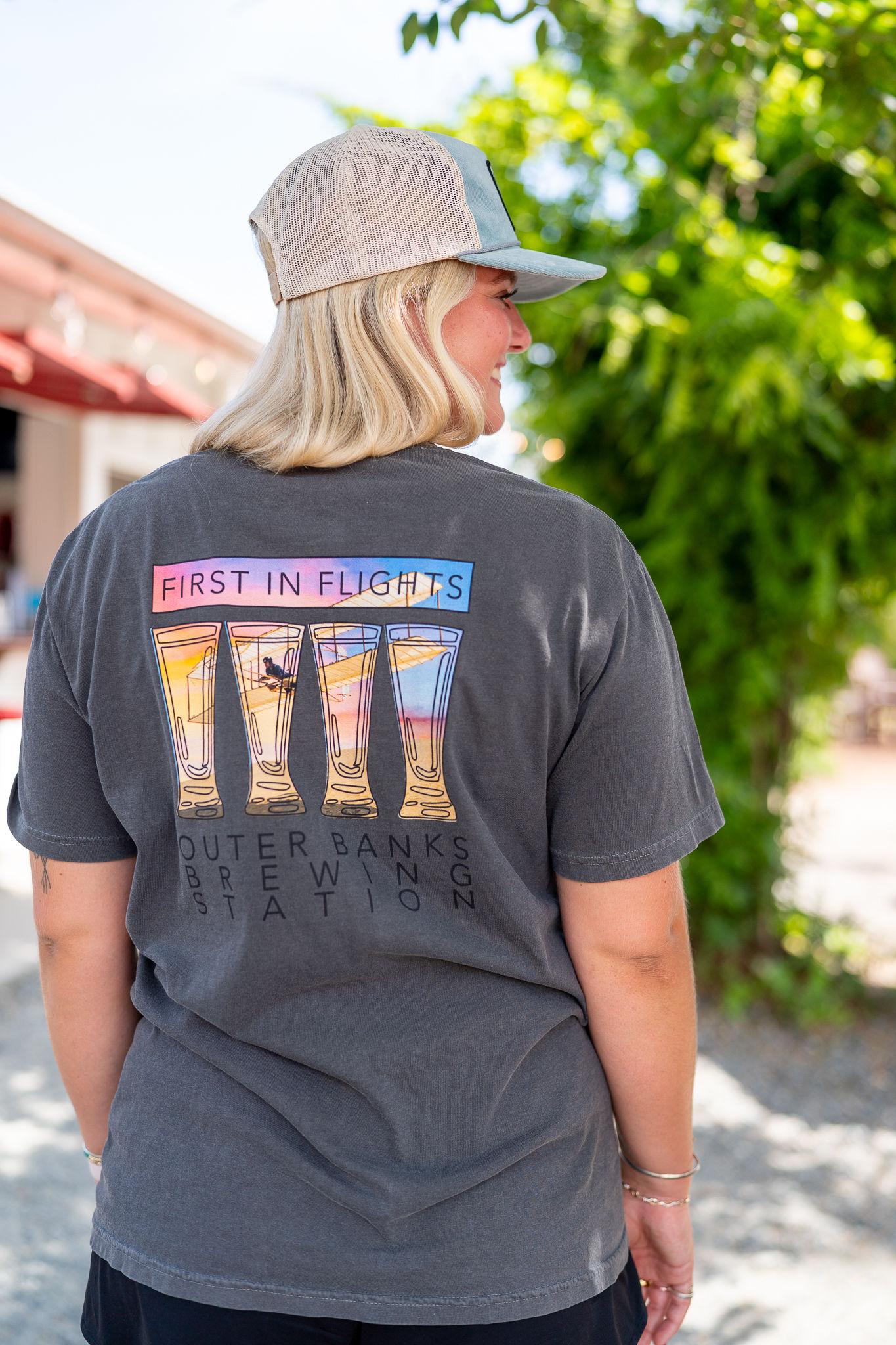 Woman wearing a grey t-shirt with OBBS beach graphics.