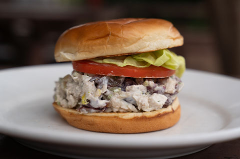 Chicken salad sandwich with lettuce and tomato on a bun