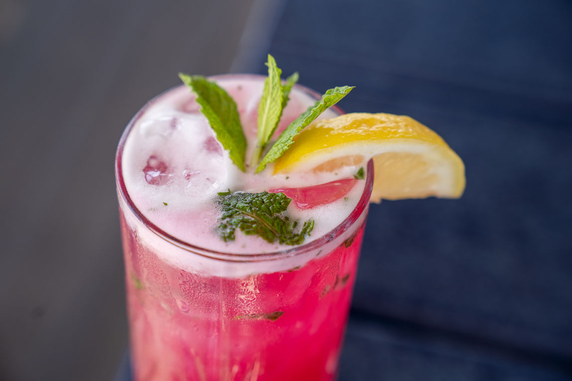 Pink cocktail with mint and lemon garnish, refreshing summer drink