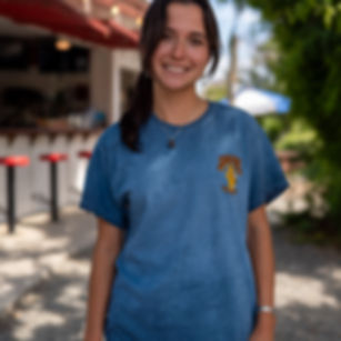 Woman in a blue Wave Set t-shirt at an outdoor bar.