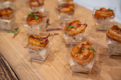 Grilled shrimp appetizers, Catering Gallery, displayed on a wooden platter, delicious food.