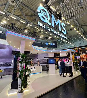 QMS at Anuga showing the large overhead logo, screens and reception area