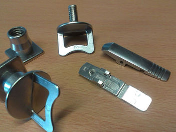 Mehrere kleine metallische Klemmen und Befestigungselemente mit Gewinde