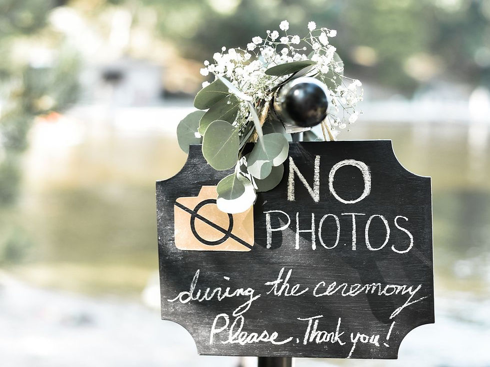 Natpis na drvenoj ploči „No photos during the ceremony, thank you“ postavljen na ulazu u vjenčanje, kao poziv gostima na unplugged ceremoniju bez mobitela