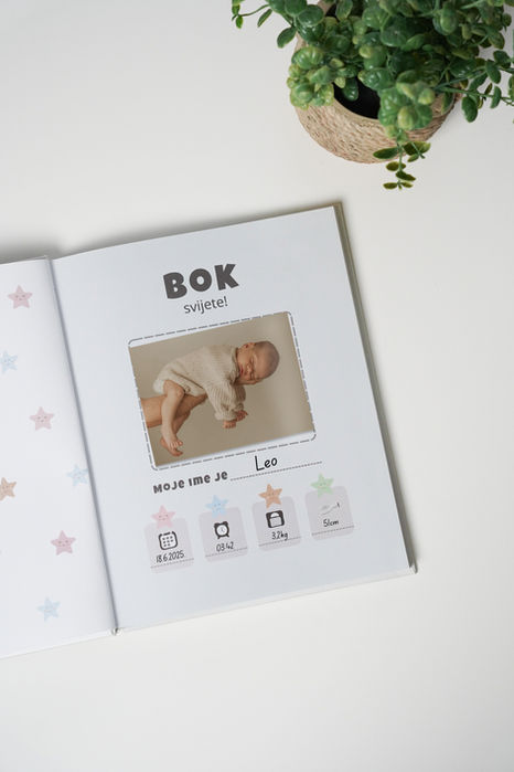 Radosnica za bebe s ispunjenom stranicom rođenja, fotografijom novorođenčeta i podacima poput imena, datuma, težine i dužine.