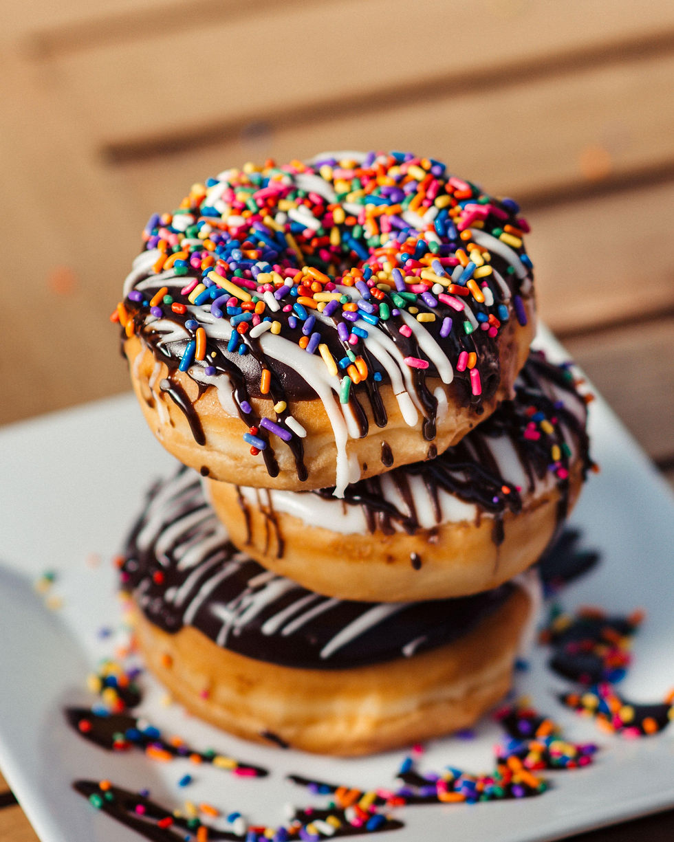 Three iced donuts stacked up on a plate