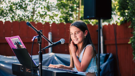 Young student smiling while performing at a school recital