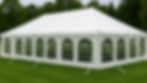 Large white event tent on a green lawn, featuring arched windows, with a backdrop of lush trees.