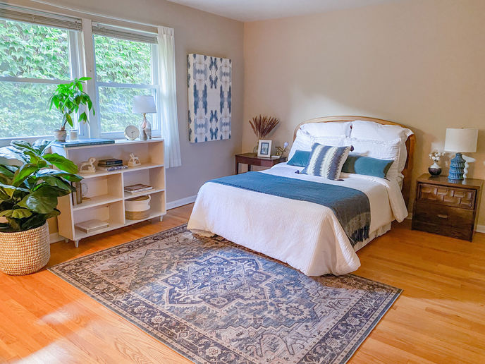 bedroom staging after Using furniture the homeowner already had. With updated bedding and the removal of a few oversized pieces, this bedroom now feels spacious, restful, and beautifully styled.