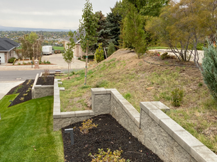 retention wall in a Utah yard, with mulch and a healthy green lawn.