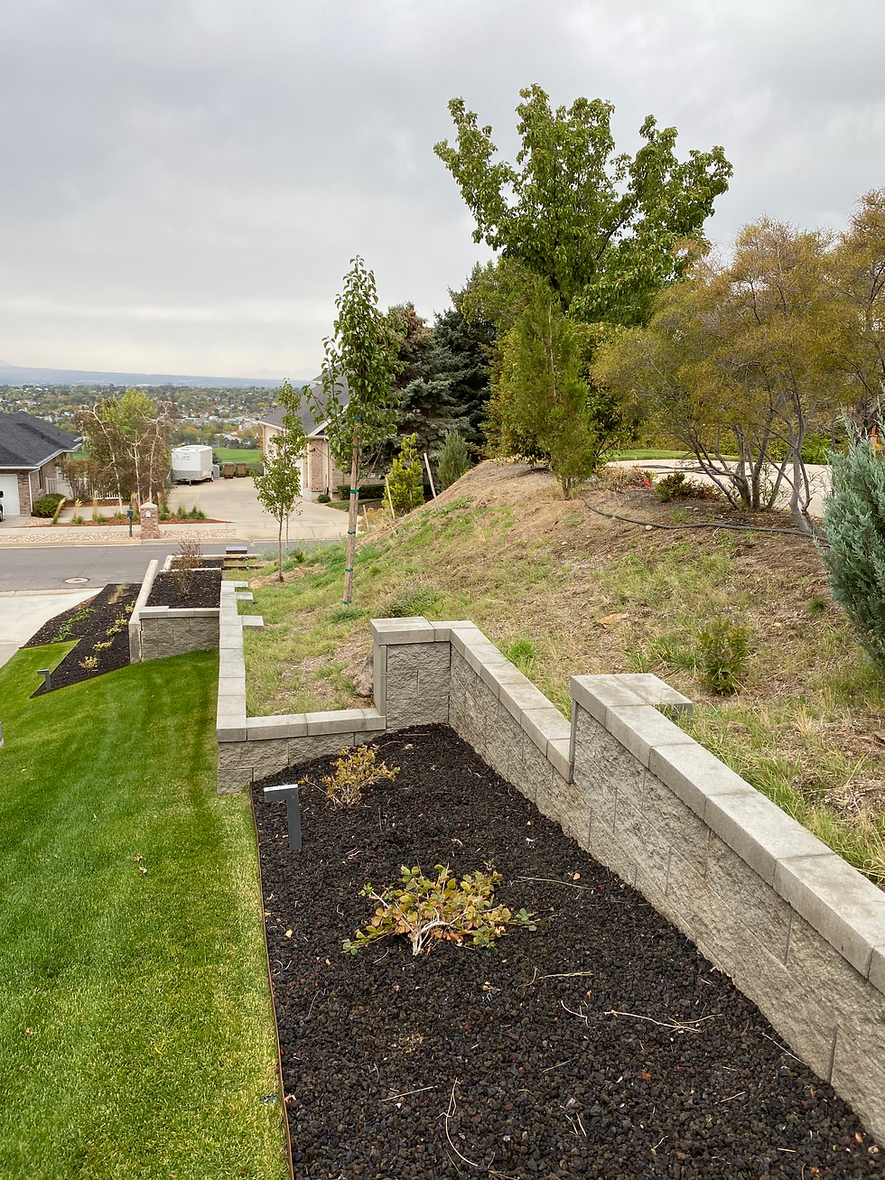 retention wall in a Utah yard, with mulch and a healthy green lawn.