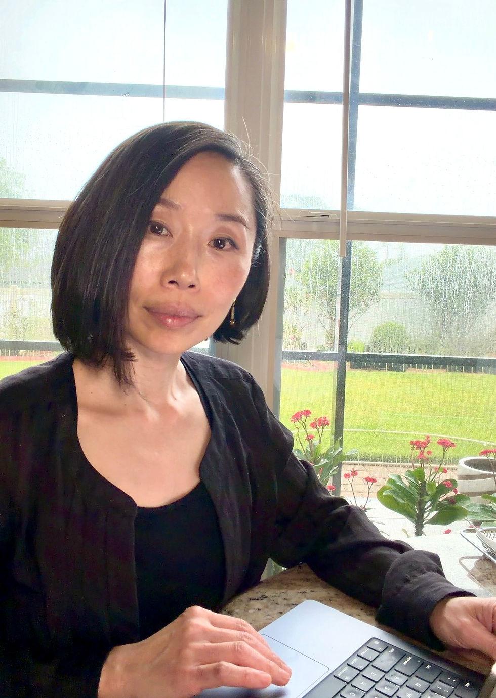 Real Estate Agent Annie Kim sitting by a window in Palm Coast, Florida