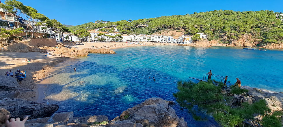 Crystal clear waters at Tamariu and kids jumping into the sea from a diving platform
