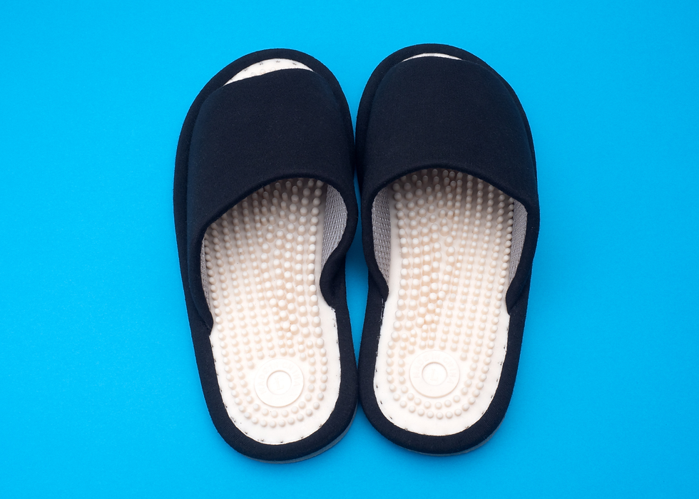 A pair of reflexology sandals with raised nodules on the footbed designed to stimulate pressure points on the soles of the feet, applying acupressure principles to support relaxation and overall wellness with every step.