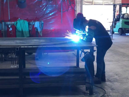 A fabricator welding a custom iron door.