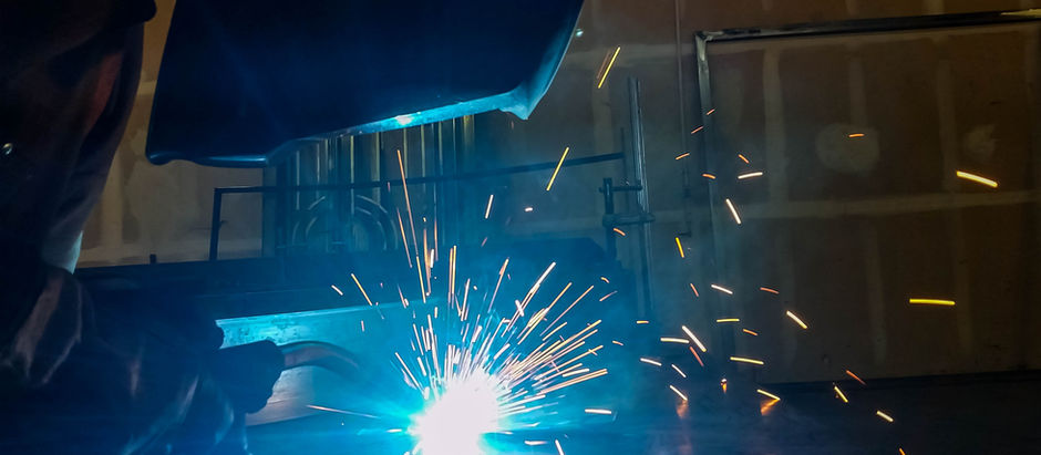 A fabricator welding a custom iron door.