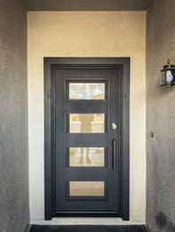 An aluminum entry door with Black powder coat, custom pull, and Clear glass.