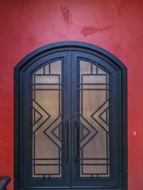 A double eyebrow arch entry door with Black powder coat, Reeded glass pattern, and custom pulls.