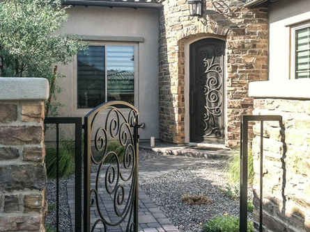 A custom iron entry door with matching iron court yard gate.