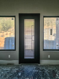 A single square entry door with Black powder coat, Reeded glass pattern, and custom pull #8.