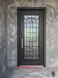 A single square entry door with Oil Rubbed Bronze powder coat, Rain glass pattern, and custom pull.