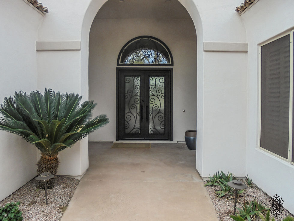 A custom iron entry door with matching transom window guard.