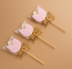 Paletas obsequio personalizadas con adorno de madera y lazo sobre fondo pastel.