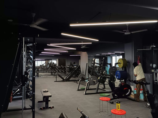Interior of a hybrid CrossFit and HYROX training floor with barbells, sleds, and rowers in Belltown, Seattle
