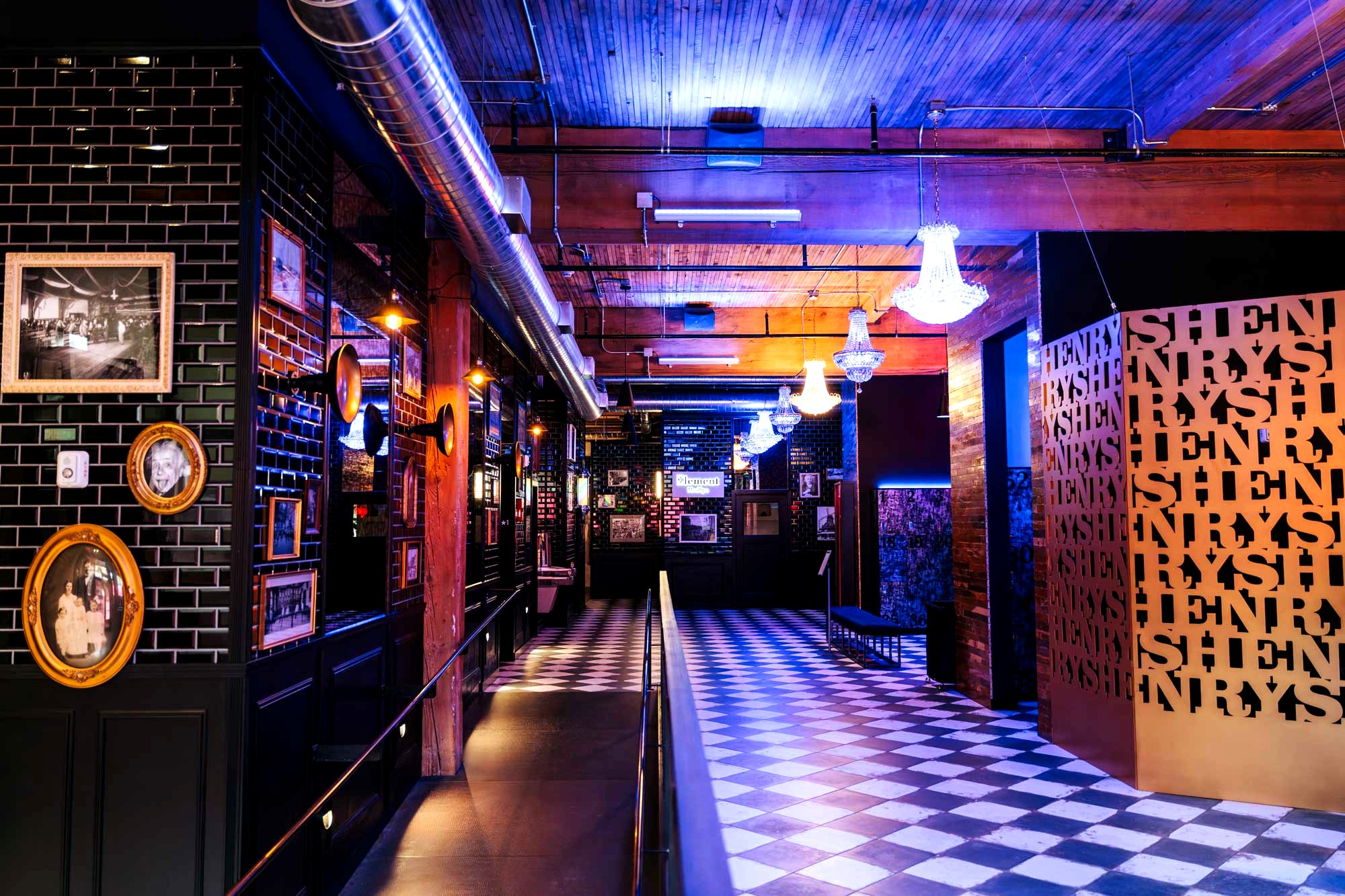 <h2>It Sounds Like a Stunt. It Isn't.</h2>
<p>Henry's Gymnasium opened in Lower Queen Anne with a pitch nobody else in Seattle was making: a full gym built inside a restored 1909 Ford Model T garage, its walls covered in three hundred historic photographs of the city, its floor plan built around a working bar. Owner Glen Swain has since proven the concept holds up. In December 2024 he opened a second, larger Henry's on Capitol Hill, roughly three times the size of the original. A niche idea that could have stayed a novelty just became a two-location company, and that expansion is the actual story worth telling here. Swain built Henry's after roughly thirty years in the fitness industry, including time at Gold's Gym and 24 Hour Fitness before he started his own company. In a sponsored interview with KING5, he described both locations as designed to be part nightclub, part museum, and part fitness space, the kind of third place people spend time in outside of work and home.</p>
<h2>Built From Seattle's Own Salvage</h2>
<p>The Queen Anne location sits at 14 Mercer St, inside a building that opened in 1909 as a Ford Model T garage and a blacksmithing apprentice shop. Roughly 80 percent of the interior is salvaged wood, pulled from a 115-year-old church, a century-old school, and a decommissioned Navy shipyard. More than 300 framed photographs of old Seattle line the walls, paired with vintage exercise equipment displayed as ephemera rather than function, and local artist Izaya Colson painted the murals. The gym runs weekdays from 6 a.m. to 10 p.m. and weekends from 8 a.m. to 6 p.m., and the front desk answers at (206) 644-0969. Even the motto commits to the bit: Be Epic.</p>
<h2>Nightclub, Museum, Gym</h2>
<p>The design backs up the words. Henry's runs an infrared sauna, red-light therapy, hydromassage, and a recovery suite alongside a standard floor of cardio machines, free weights, and racks. The bar pours smoothies, wine, and beer. There's no public class schedule the way a studio gym publishes one. Training happens through personal or group sessions booked directly, and the rest of the day the floor, the recovery suite, and the bar are simply open. That's a structural choice, not an oversight. Henry's isn't selling a 6 a.m. spin class. It's selling a building people want to spend time in.</p>
<h2>The Bet That Just Doubled</h2>
<p>The clearest evidence the concept works showed up as a real estate transaction, not a five-star review. In December 2024, Swain opened a second Henry's inside the historic Boylston Garage at 1617 Boylston St on Capitol Hill, a building owned by Asana Partners. At 15,000 square feet, it's roughly three times the footprint of the Queen Anne original, and the deal drew coverage from Capitol Hill Seattle Blog and commercial real estate outlets including Hughes Marino, The Registry PNW, and Connect CRE, not just from Henry's own marketing. Swain framed the new building around community and diversity, honoring the neighborhood's history through art rather than treating it as decoration. The gym's designer, Jeff Nagel of NAGELsport, called it among the most ambitious builds his firm has taken on, describing the level of design as a gift to the people using the space rather than a showpiece for its own sake.</p>
<h2>Capitol Hill Tells a Different Story</h2>
<p>Capitol Hill isn't a bigger copy of Queen Anne with a new zip code. Three full-wall murals honor the 1969 Stonewall riots and Harvey Milk, and more than 100 additional pieces of LGBTQ+ heritage art fill the space, a deliberate departure from Queen Anne's general Seattle history collection. Henry's also donates a portion of its monthly guest fees to Lambert House, the Seattle nonprofit that serves LGBTQ+ youth, according to Seattle Gay News. The art isn't decoration bolted onto a gym. It's the organizing idea of the room.</p>
<h2>What Membership Actually Costs</h2>
<p>Queen Anne prices two tiers. The Preferred Basic Wellness plan runs $89.99 a month. The All-Inclusive Wellness plan runs $199.99 a month and adds four monthly sessions each of red light therapy, hydromassage, infrared therapy, and cryomassage, plus unlimited vibration-plate use and a monthly InBody body-composition scan. Both tiers carry a one-time $99 processing fee. Capitol Hill's premium tier covers similar ground with one swap: it includes Frost Locker cold-therapy treatment and unlimited Finnish sauna in place of the cryomassage and InBody scan Queen Anne offers. Neither location publishes a public class calendar. What members are paying for, across both buildings, sits closer to a private athletic club with a bar attached than a typical chain gym membership.</p>
<h2>The Complaint on File</h2>
<p>The concept has real fans. Henry's holds a 4.6 to 4.7 average across Yelp and Birdeye, a Top Rated Service 2026 badge on Birdeye, and consistent praise for cleanliness, equipment quality, and atmosphere. It also has a Better Business Bureau file worth reading before signing up: a B+ rating, no BBB accreditation, and five complaints on record. Two are specific enough to name. One customer says Henry's charged a membership fee roughly 61 days after a cancellation request, with the billing communication described as aggressive. Another traces back to the Capitol Hill launch, over a delayed opening tied to a trial membership. Five complaints against hundreds of positive reviews reads less like fraud and more like ordinary friction over a cancellation policy, worth reading closely before signing anything. Swain didn't just build a gym people like. He built one that repeats, in two neighborhoods now, on a bet that a gym could be somewhere people actually want to spend an evening.</p>