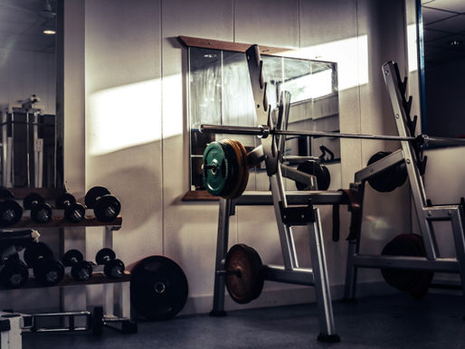 Barbell racks and benches inside a 24-hour strength gym in Belltown, Seattle